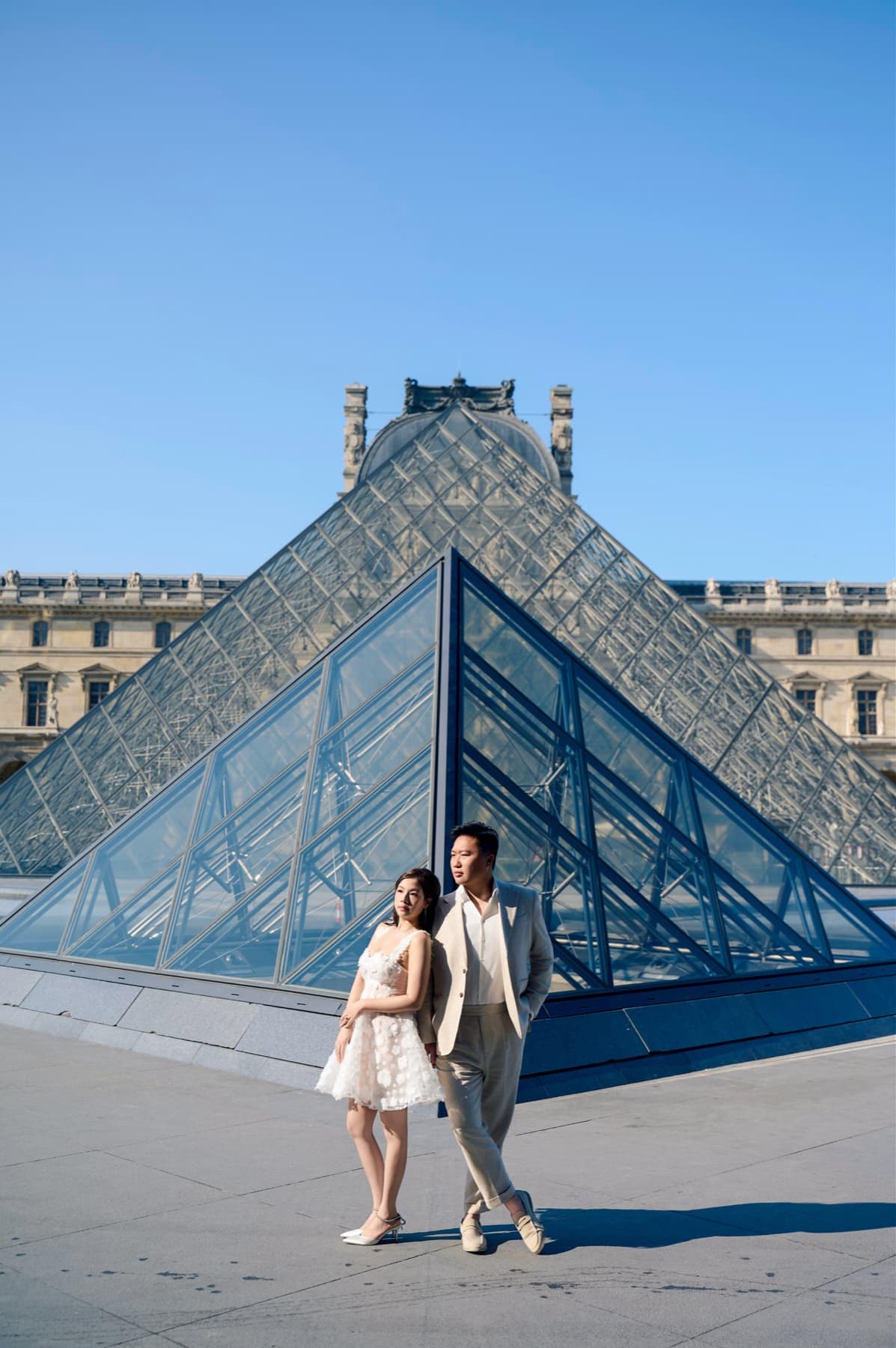 Natalie and Bryan standing together in front of the Louvre Pyramid