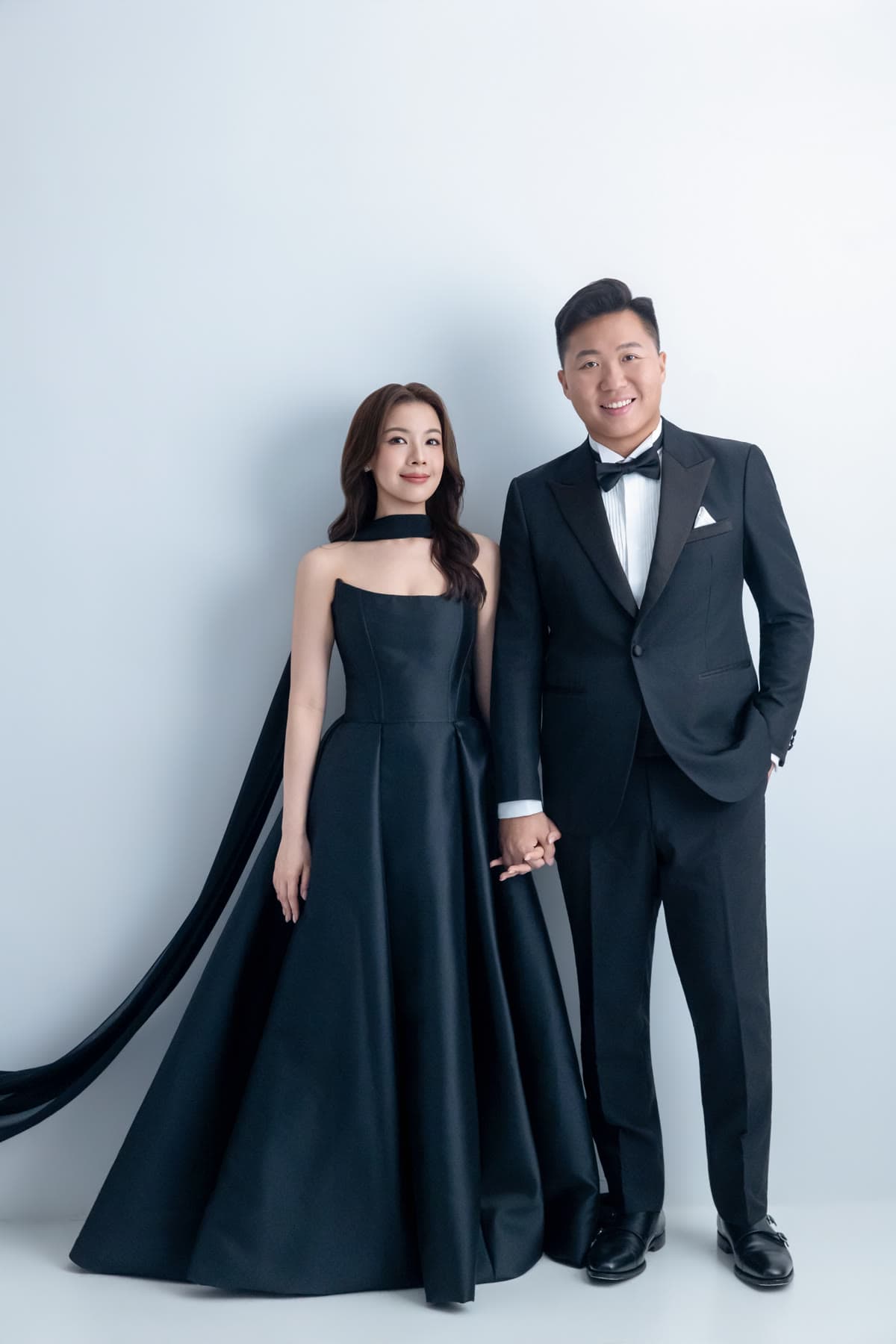 Natalie and Bryan standing together in coordinated black formalwear