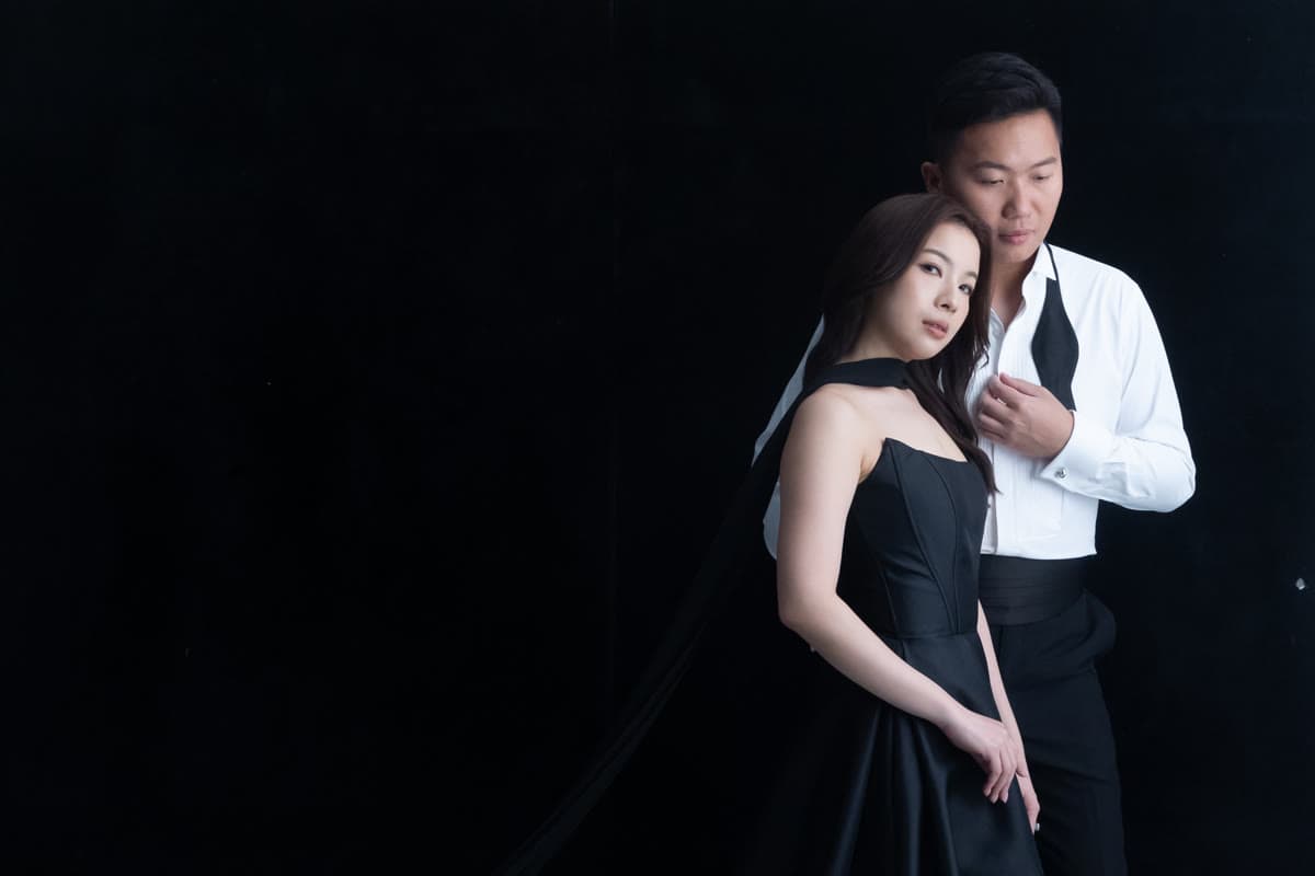 Natalie and Bryan sharing a dramatic studio portrait in black formalwear