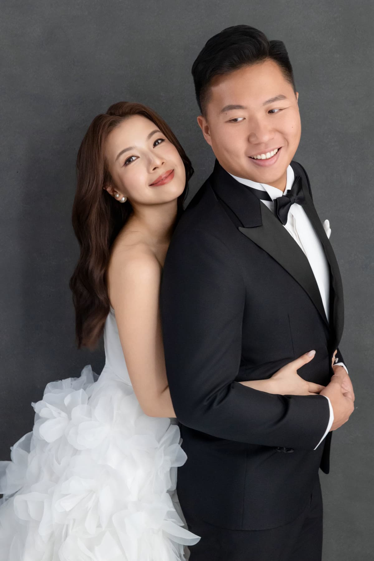 Natalie and Bryan smiling together in a black-and-white studio portrait