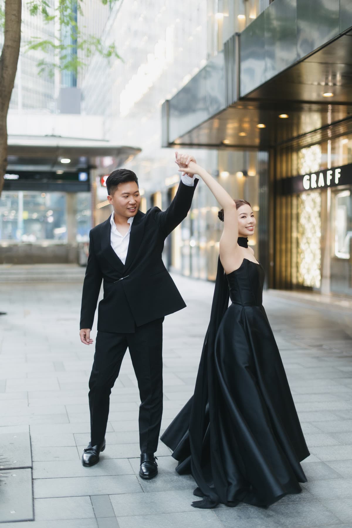 Natalie and Bryan posing outside in black evening attire
