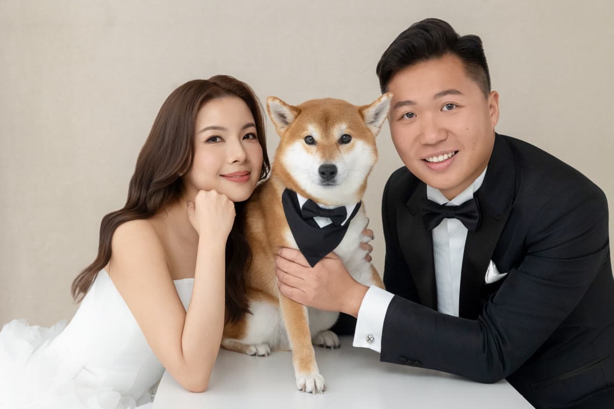 Natalie and Bryan posing with their dog in formal attire