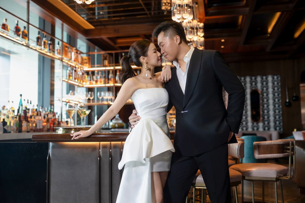 Natalie and Bryan sharing a kiss beside the bar
